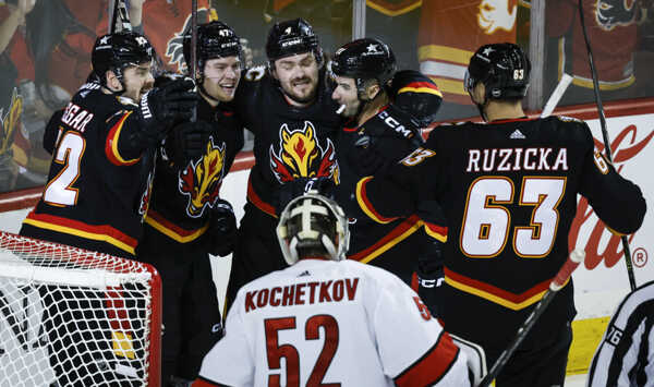 Vpravo slovenský útočník Calgary Flames Adam Ružička oslavuje gól so spoluhráčmi.